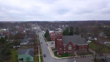 aerial view flying across quiet sheridan town autumn neighbourhood towards indiana methodist church