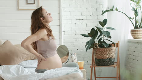 Pregnant-belly-woman-standing-in-room.-Expecting-mother-looking-window-at-home