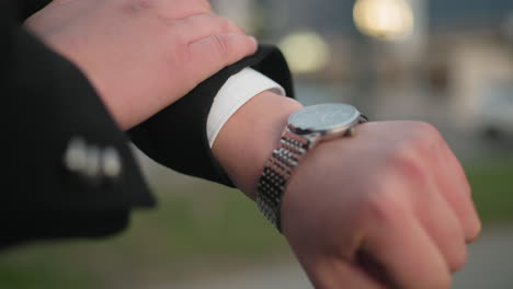 close up of hand opening suit cloth to check time, blurred background with unclear object, focus on hand gesture, sign of professionalism and time management in business environment