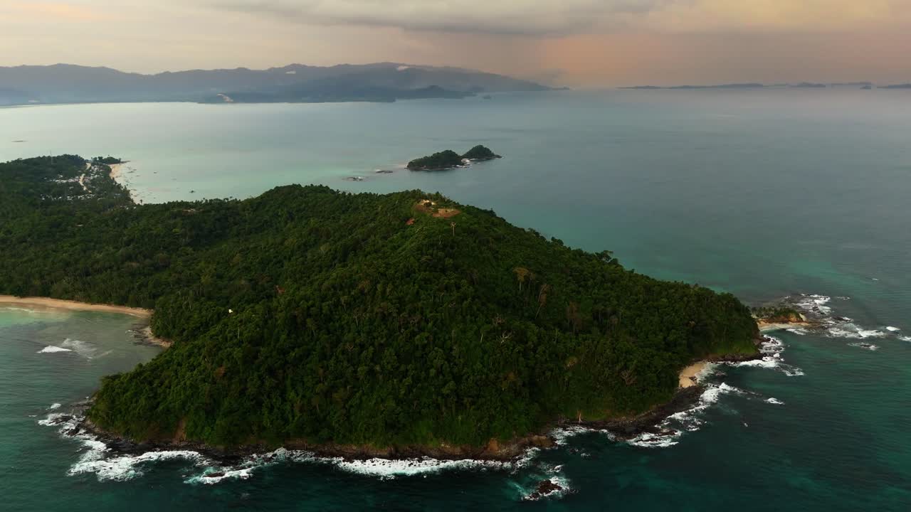 drone shot over the lush green mountains and pristine coastline of San Vicente, Palawan. Features crystal clear turquoise waters and a remote tropical beach