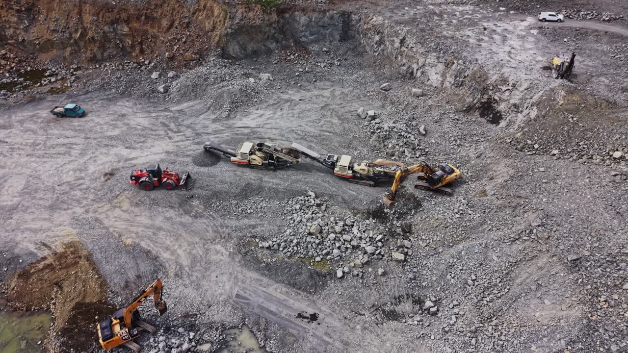 Aerial View of Heavy Machinery Working in a Large Open Pit Quarry