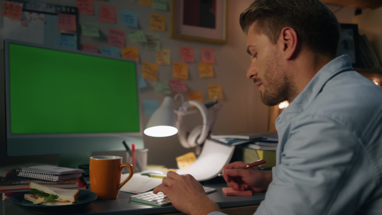 Nærbillede af engageret mand, der taster på en mockup-computer. Seriøs fyr ser på grøn skærm.