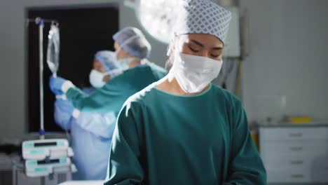 Video-Einer-Asiatischen-Chirurgin,-Die-Instrumente-überprüft,-Schaut-Im-Operationssaal-In-Die-Kamera,-Kopierraum