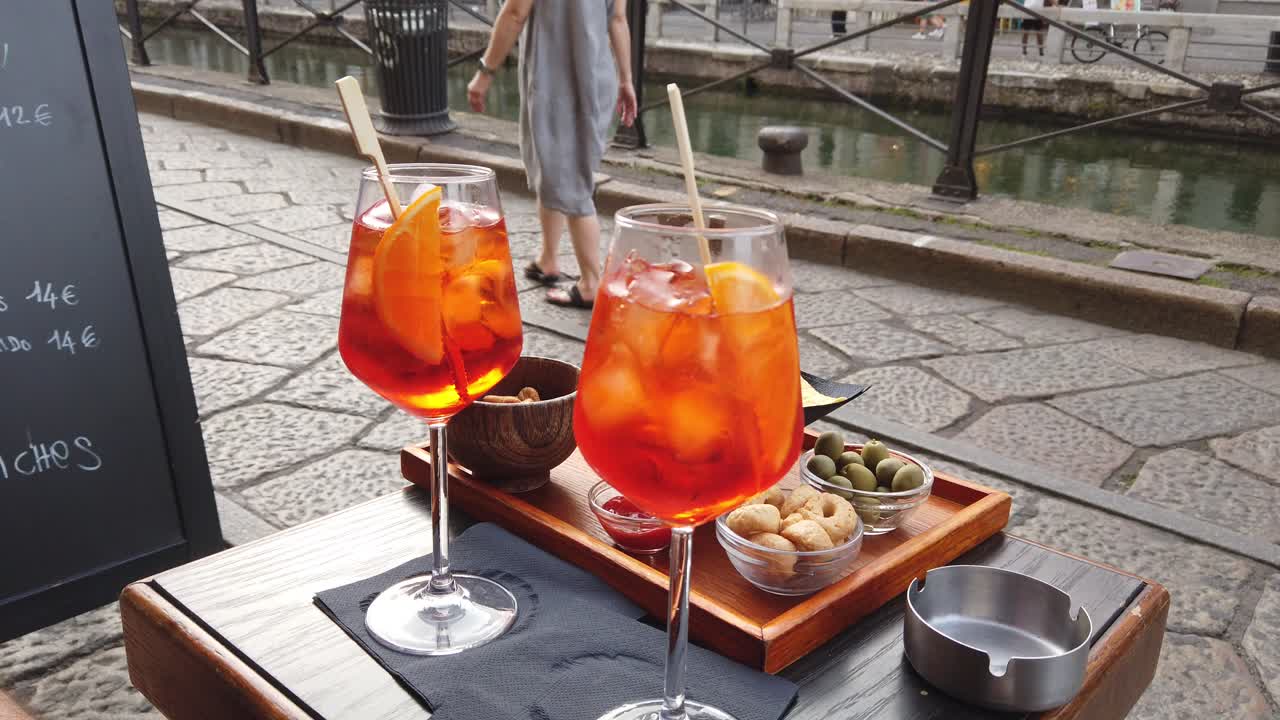 Golden hour spritz cocktail served outdoors in Milan’s Navigli district, Italian aperitivo culture at sunset