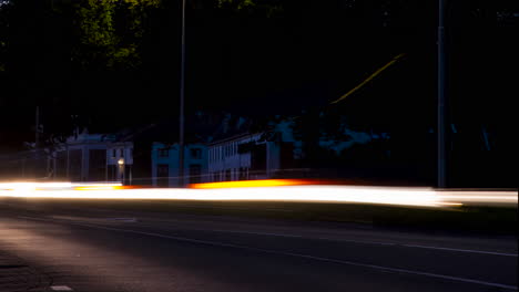 Time-lapse-of-fast-driving-traffic-with-headlights-on-at-sunset---pan-right-to-left