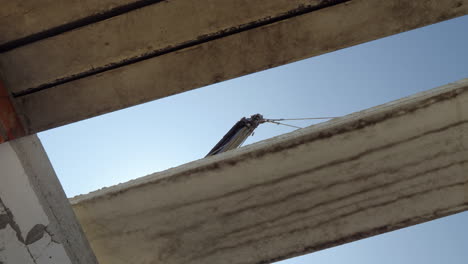 a crane installs a floor panel in a multi-storey building a bottom view