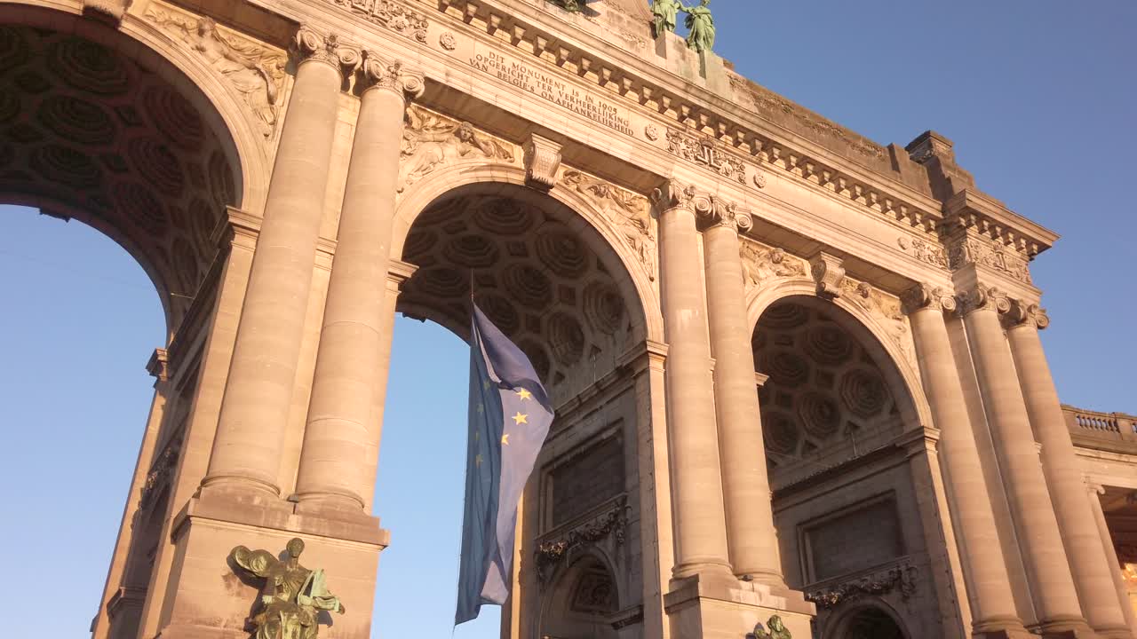EU flag and Cinquantenaire monument at sunset