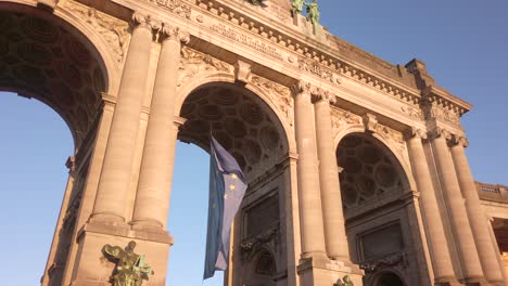eu flag and cinquantenaire monument at sunset