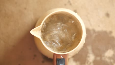 agua hirviendo en una olla de café turca eléctrica beige
