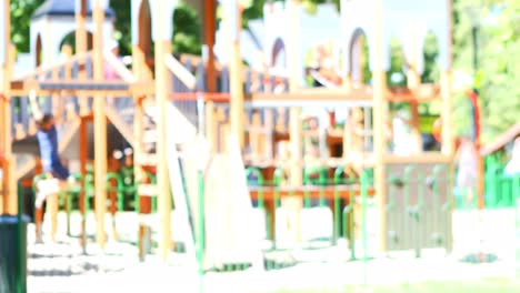 A-young-woman-stands-in-front-of-a-children's-playground,-smiling-and-posing