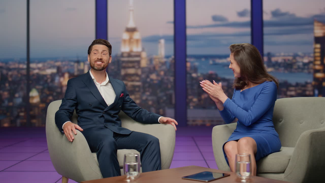 Tv show presenter interviewing man guest in modern television channel studio