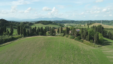 luxury villa with solar panels on roof behind cypress trees on hill in italy