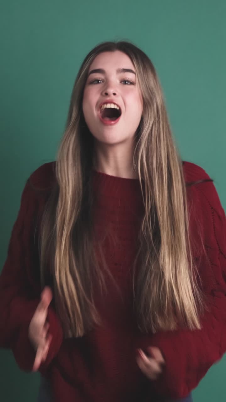 Beauty young woman jumping raising fists celebrating