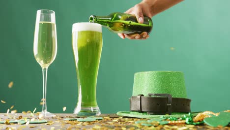 Video-of-st-patrick's-glass-of-champagne,-beer,-hat-with-copy-space-on-green-background