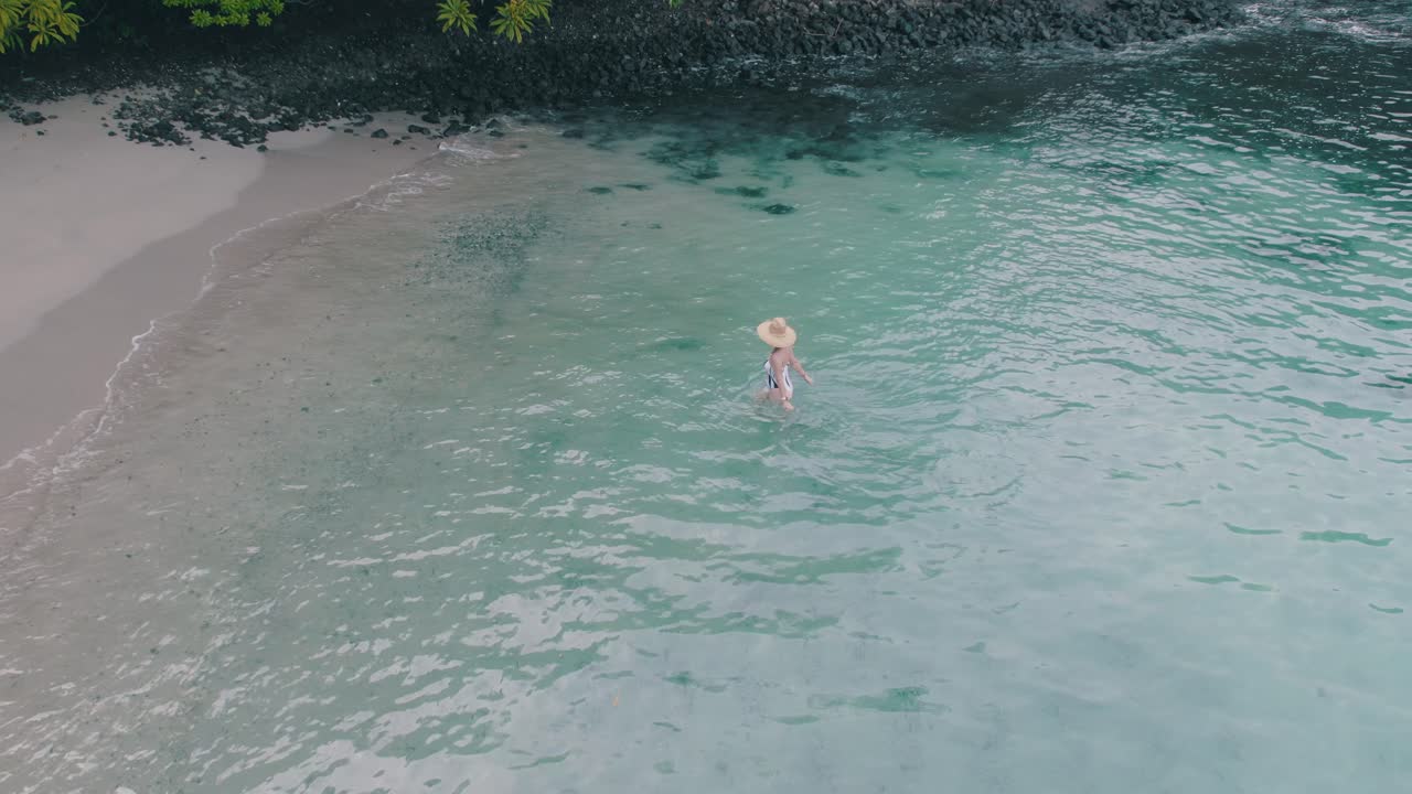 Woman enjoys clear tropical water at a serene beach