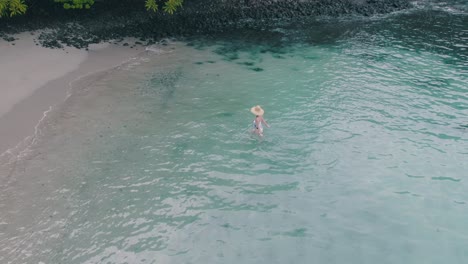 woman enjoys clear tropical water at a serene beach
