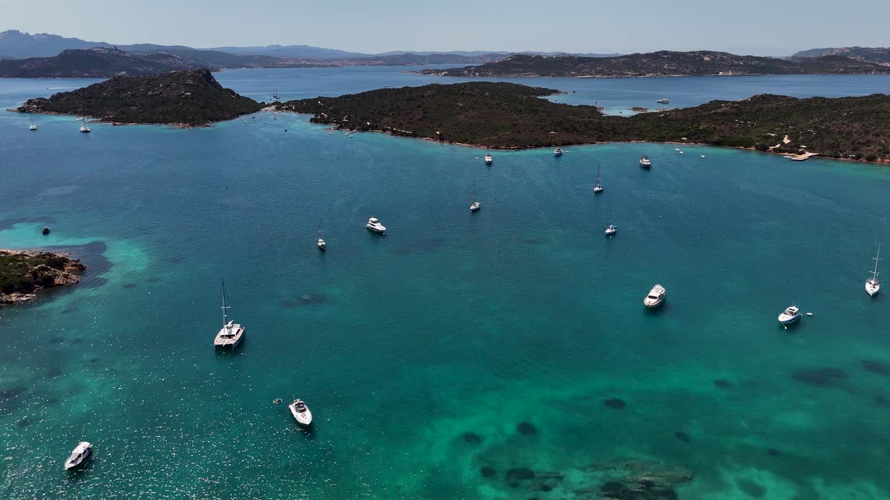 Calm yachts in clear blue Sardinian sea under sunny skies