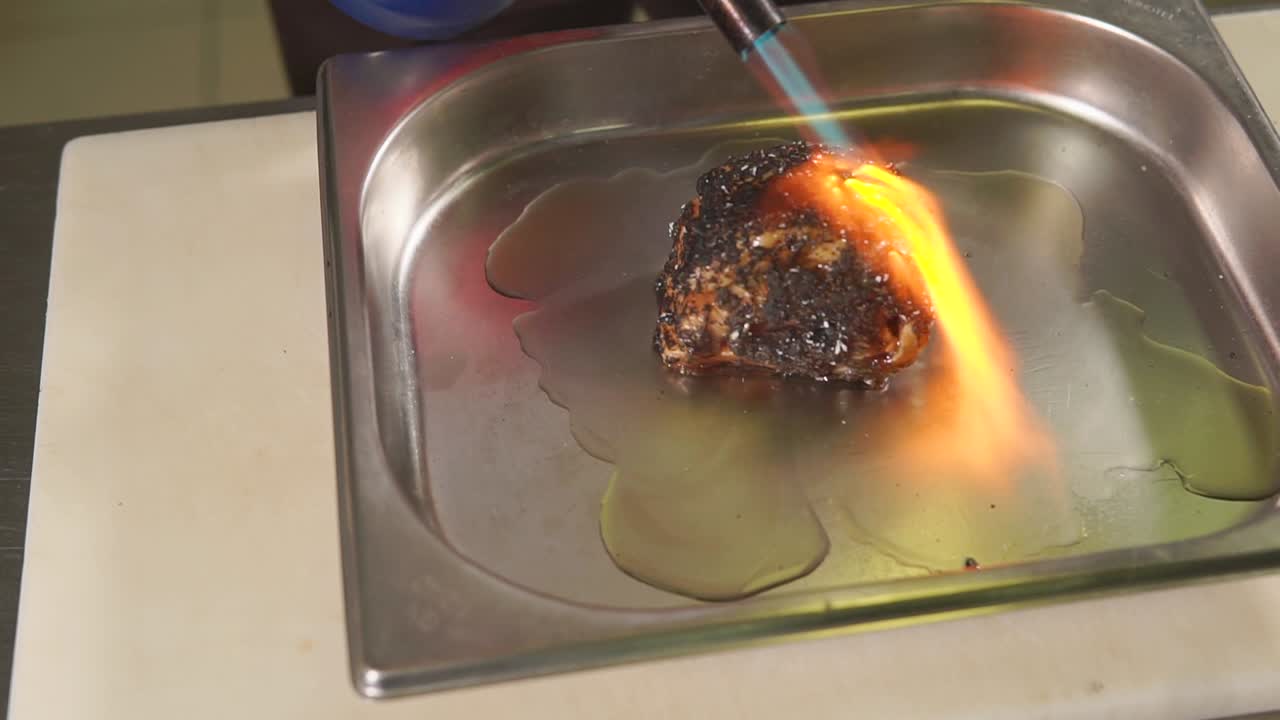 요리사 가 불 으로 음식 을 고 있다