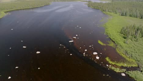 High-Wide-Aerial-View-Shows-Boat-Docked-Near-Rocks-in-a-Canadian-Lake