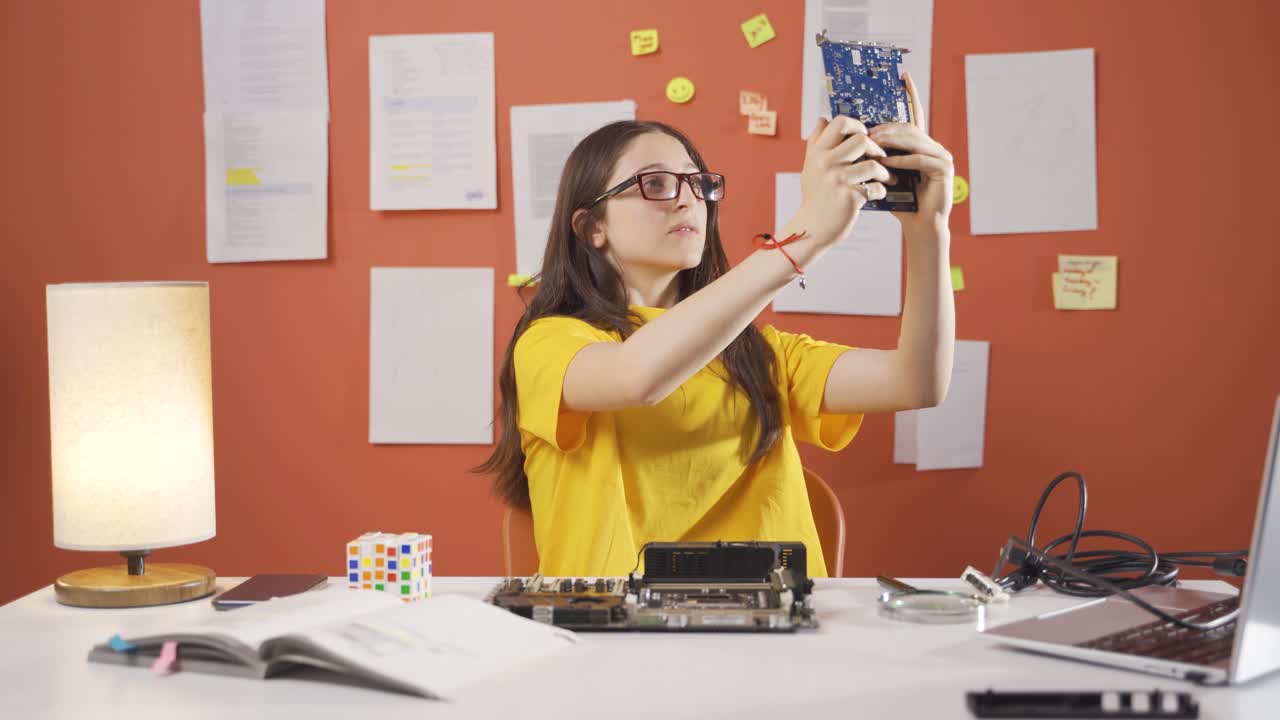 niña inteligente mirando con asombro a los materiales tecnológicos.