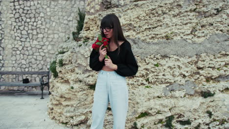 woman outdoor smelling the flowers she received for valentines day