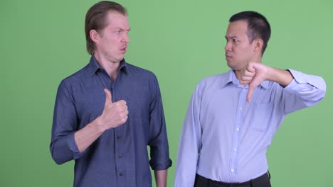 two businessman having different opinions against green studio background