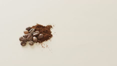 Video-of-pile-of-roasted-brown-coffee-beans-over-white-background