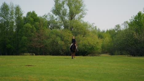 woman horseback riding in a meadow