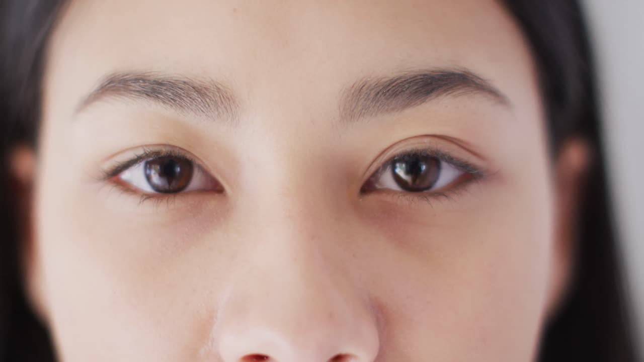 어두운 머리카락을 가진 미소 짓는 두 인종의 여성의 초상화의 클로즈업 비디오