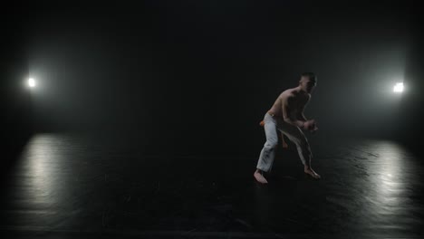 luchadores de capoeira realizando movimientos dinámicos en el escenario. artes marciales, danza y acrobacias en acción. atletas de pecho desnudo mostrando fuerza, flexibilidad y técnica bajo los reflectores