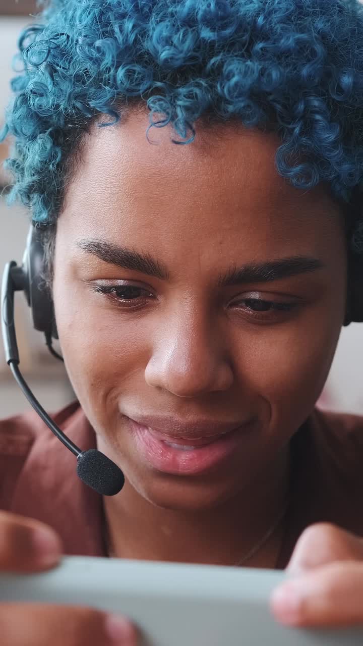 Young cheerful african american woman in headphones plays game on mobile phone