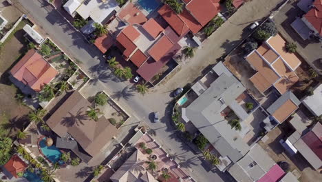 un auto conduciendo por una calle residencial en noord, aruba