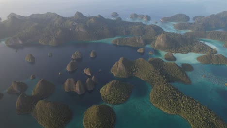 sunset fly around many island formations, lagoons with sandy areas around in raja ampat, wayag, indonesia, papua