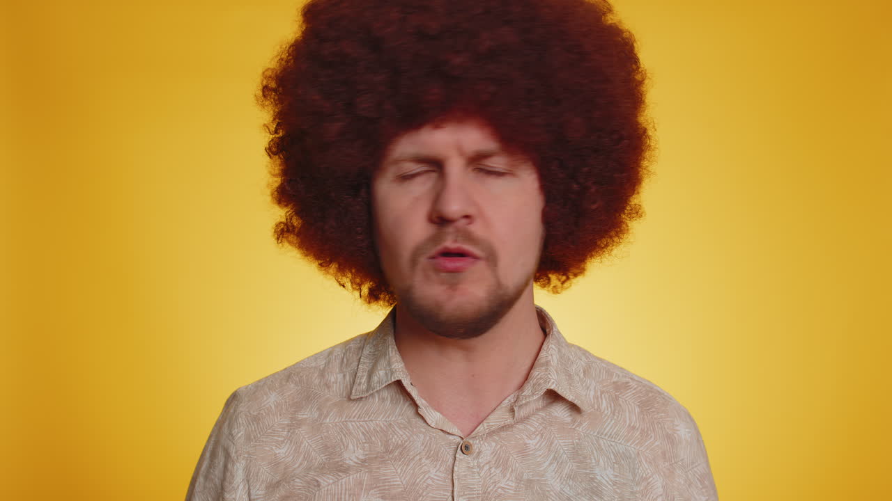 hombre gracioso con peluca afro posando con el dedo apuntando