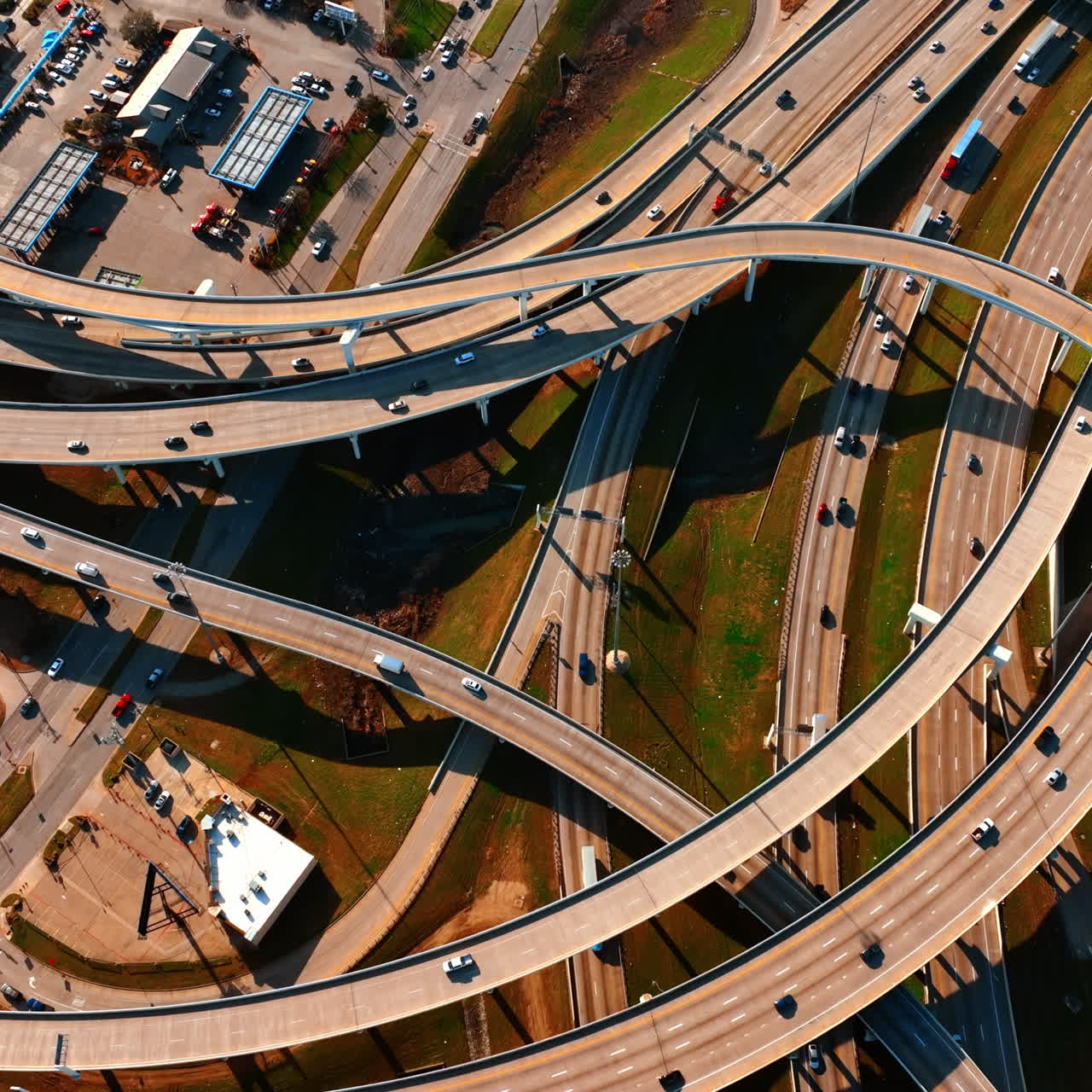 Cars move by the roads and freeways in Dallas, Texas, USA. Top view of the highways on sunny daytime