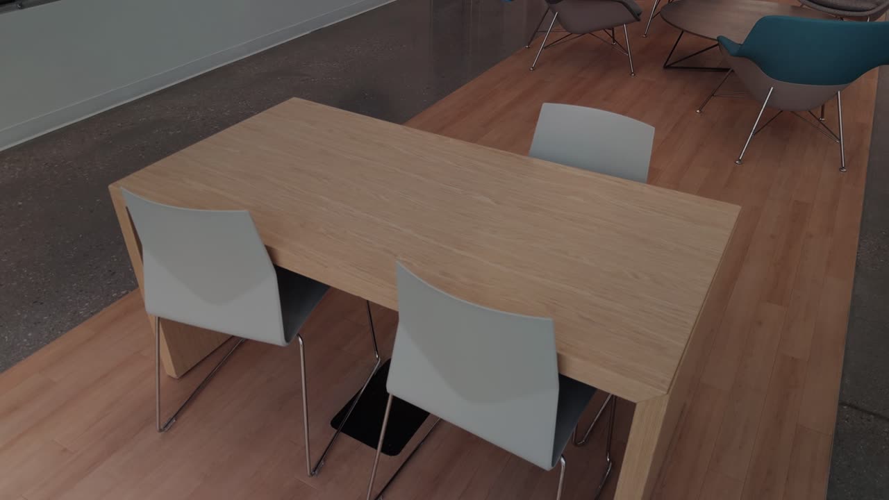 Lenta panoramica da destra a sinistra su un tavolo e sedie in legno all'interno di un moderno spazio di lavoro.