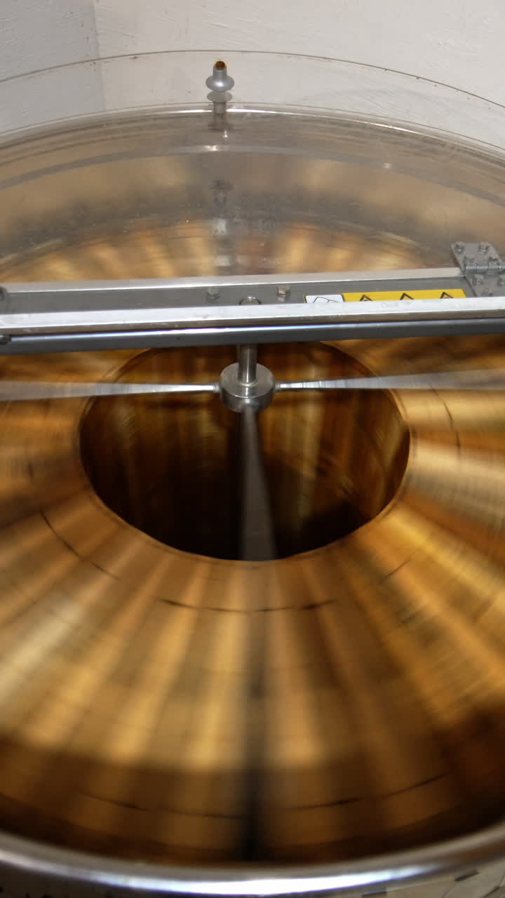 Electric device rotating frames with honey. Machine with opened lid working in the apiary. View from top. Vertical video