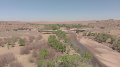 antena sobre un río seco con un puente