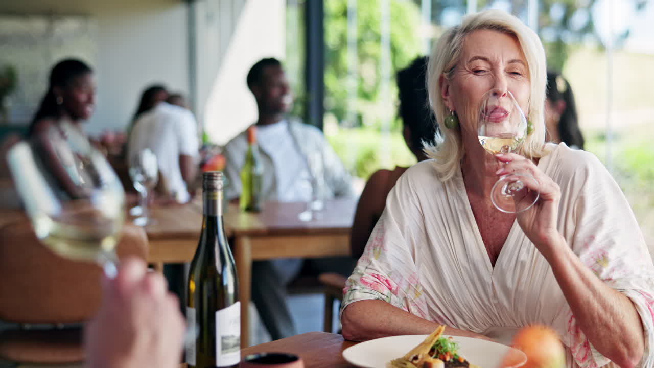 Happy Senior Woman Laughing and Drinking Wine at Restaurant