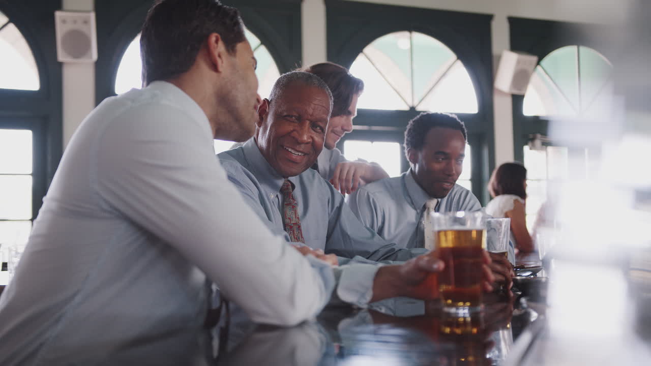 사업가 들 의 그룹 이 술집 에서 일 후 음료 를 마시기 위해 모인다