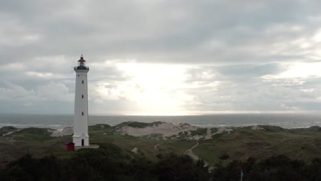 Aerial-footage-of-a-lighthouse-near-the-shore-on-the-western-coast-of-Jutland,-Denmark