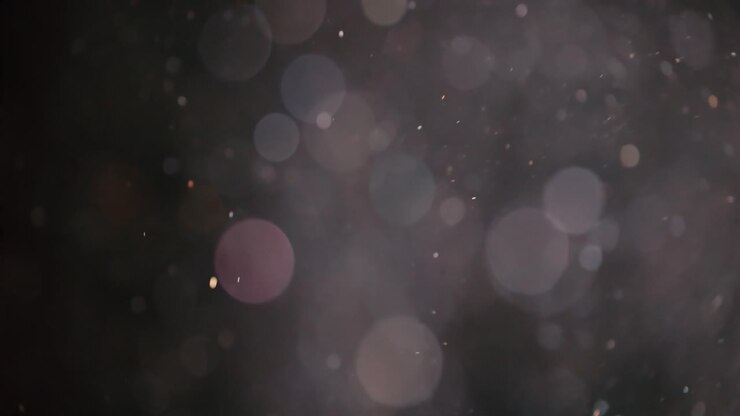 Floating abstract particle bokeh on dark background