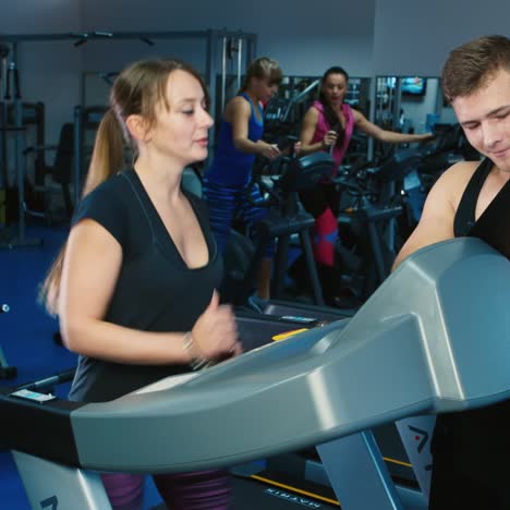 a woman trains in the gym with personal trainer