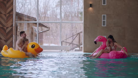 family with children is resting in new modern wellness center with thermal pool father mother son and daughter