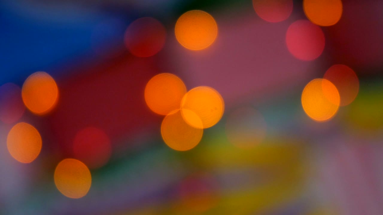 Blurred colorful lights. Red, green, yellow, orange, blue defocused glittering bokeh festive background.