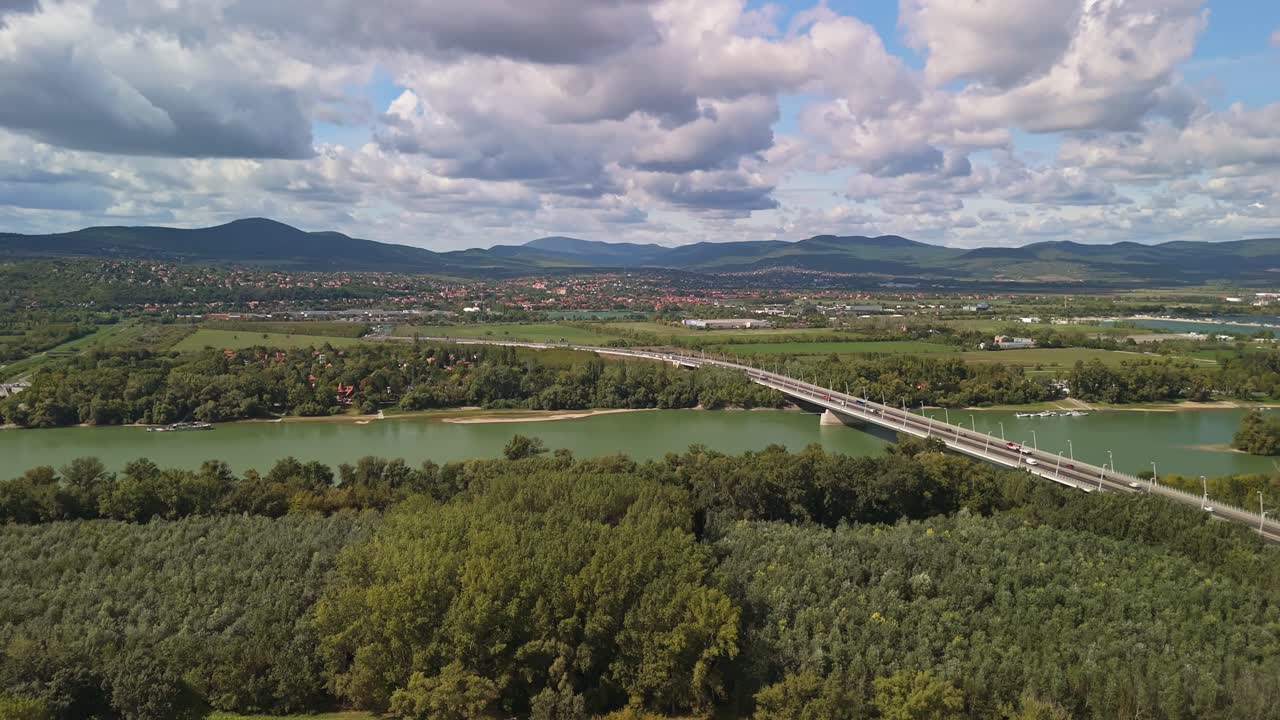 M0 ring road leads to Budakalász as the exit section of the Megyeri Bridge with the Buda Hills in the background on a sunny, cloudy day in Budapest, Hungary