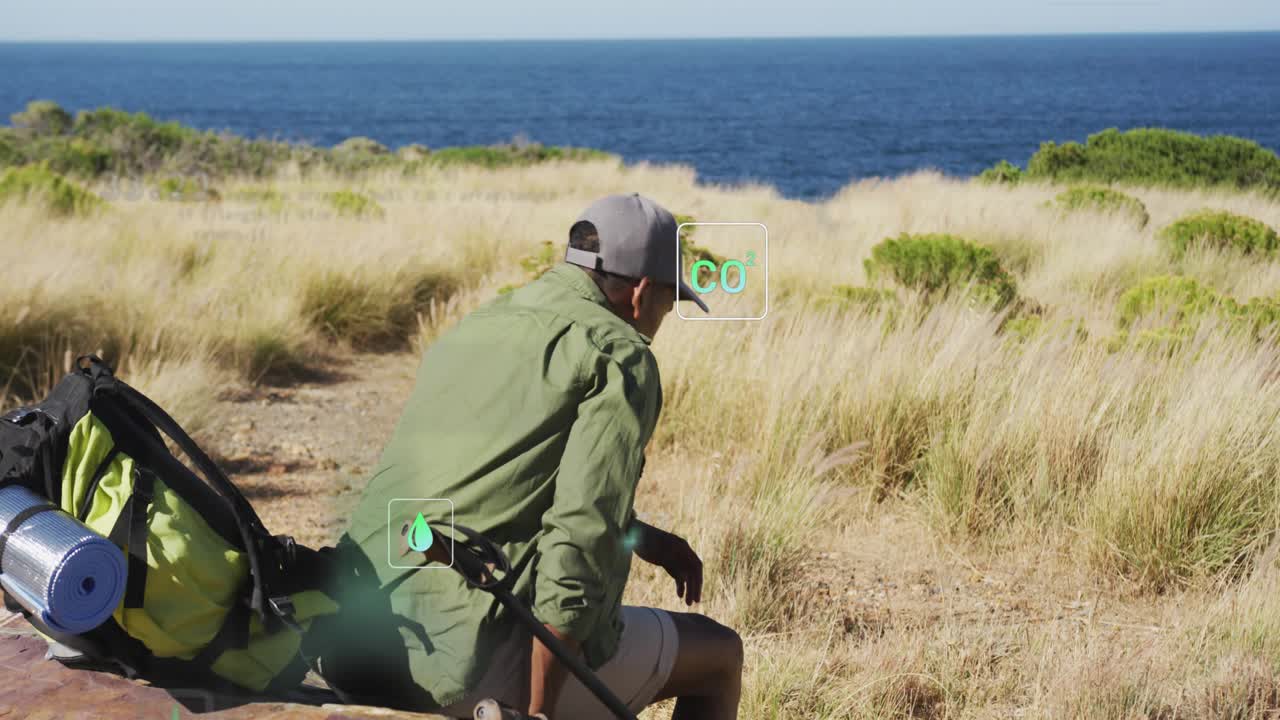 Uomo che cambia posizione sul sentiero e attiva icone AR mentre prepara l'attrezzatura per il monitoraggio delle metriche ecologiche.