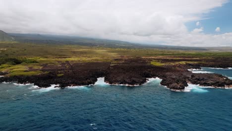 idyllic sea with waves crashing against dark lava rocks on the big island of hawaii