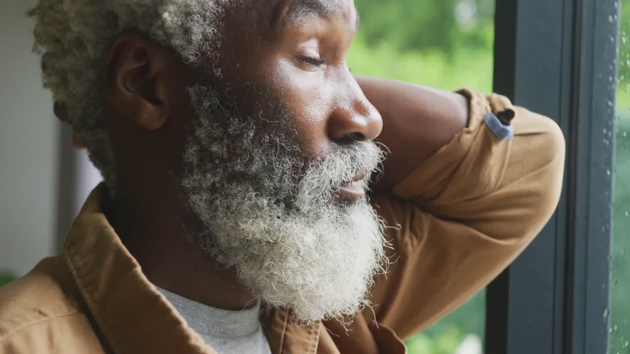 Vidéo d'un homme âgé afro-américain triste regardant par la fenêtre