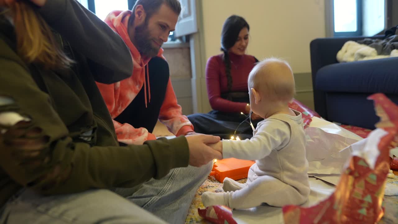 아기와 함께 선물을 열어주는 가족